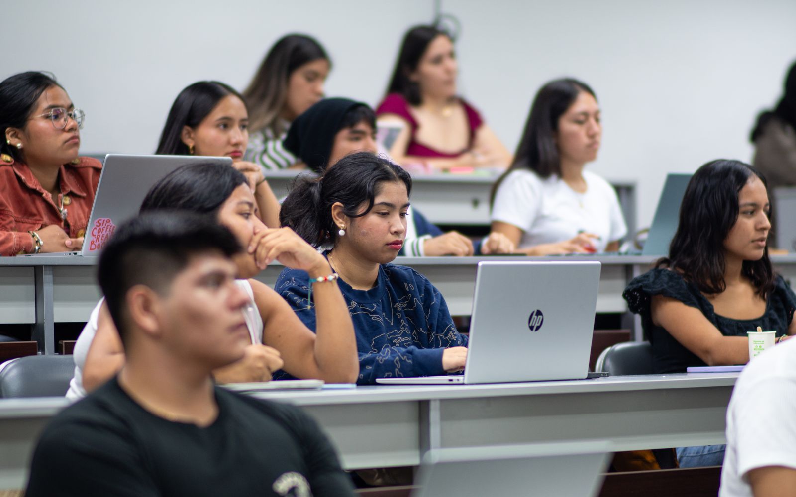 Adult student studying with a laptop in a college lecture hall